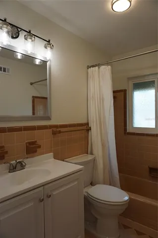 a bathroom with a sink a toilet a mirror and shower