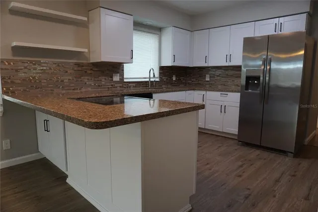 a kitchen with stainless steel appliances granite countertop a refrigerator sink and cabinets