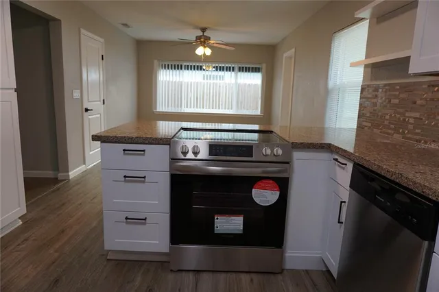 a kitchen with granite countertop a stove and a refrigerator