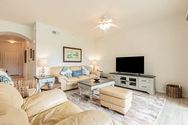 a living room with furniture and a table with garden view