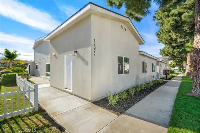 a white car parked in front of a white house