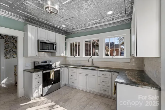 a kitchen with stainless steel appliances granite countertop stove top oven a sink dishwasher and a microwave oven on the blue kitchen countertops