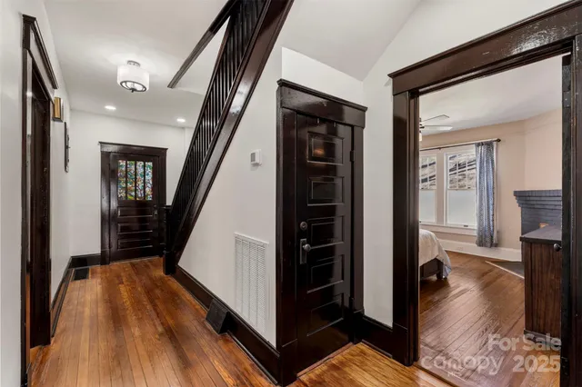 a view of a hallway with wooden floor and staircase