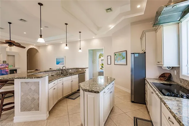 a kitchen with stainless steel appliances granite countertop a stove a sink and a refrigerator