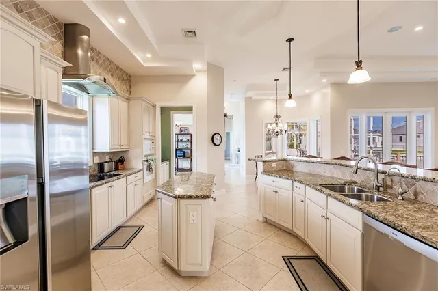 a large kitchen with granite countertop lots of counter space and stainless steel appliances
