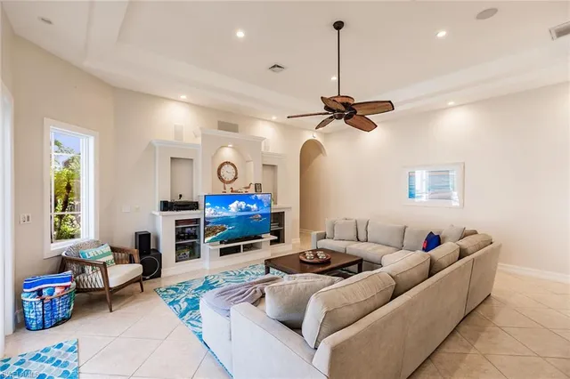 a living room with furniture a ceiling fan and a window