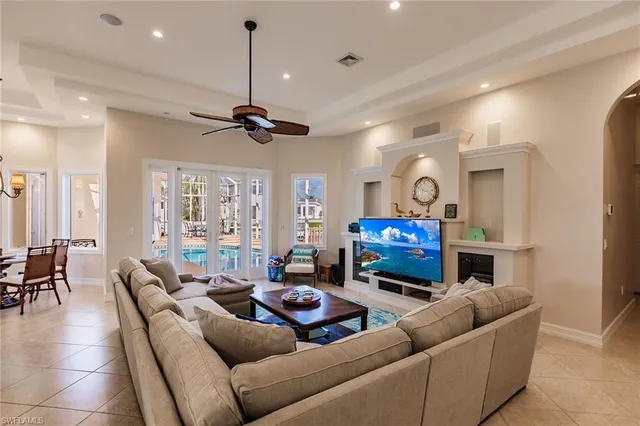 a living room with furniture a fireplace and a chandelier