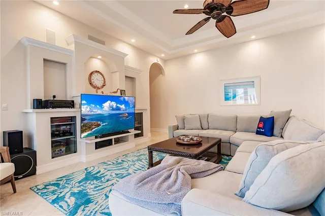 a living room with furniture a flat screen tv and a view of kitchen