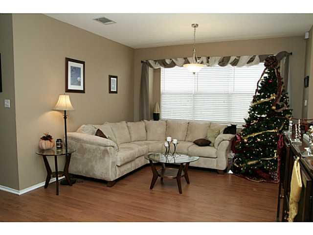 16903 Gravesend Road Pflugerville, TX 78660 - Photo 1 of 1 a living room with furniture and a chandelier