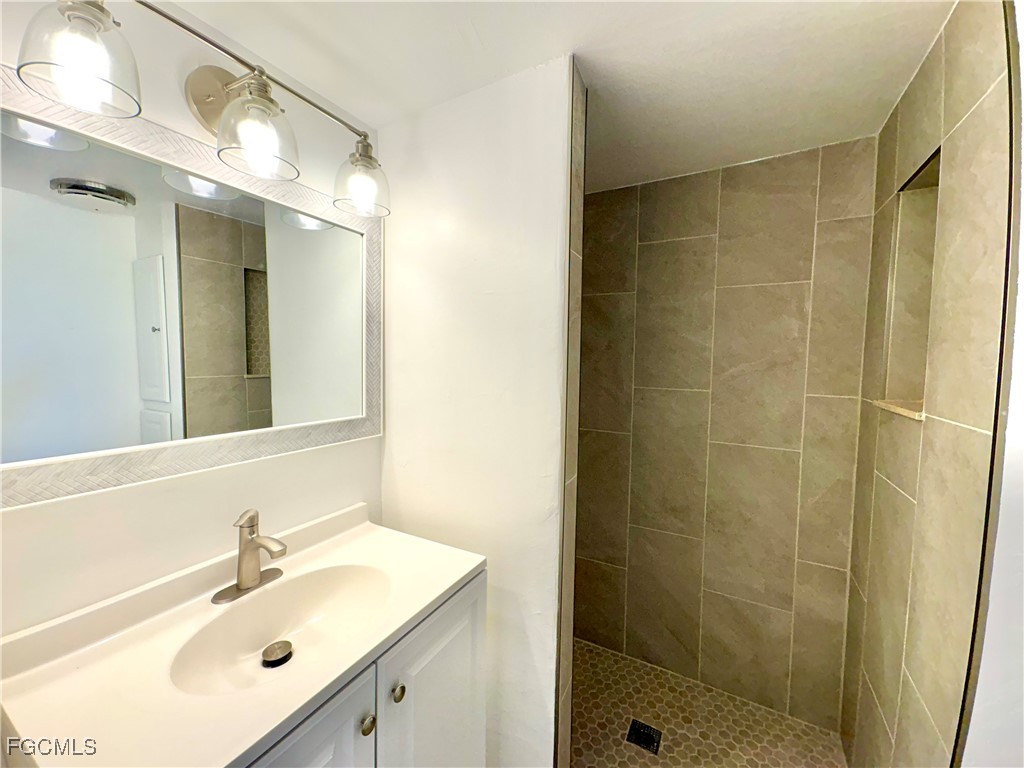 5675 Pine Island Road St. James City, FL 33956 - Photo 26 of 28 a bathroom with a sink mirror and shower