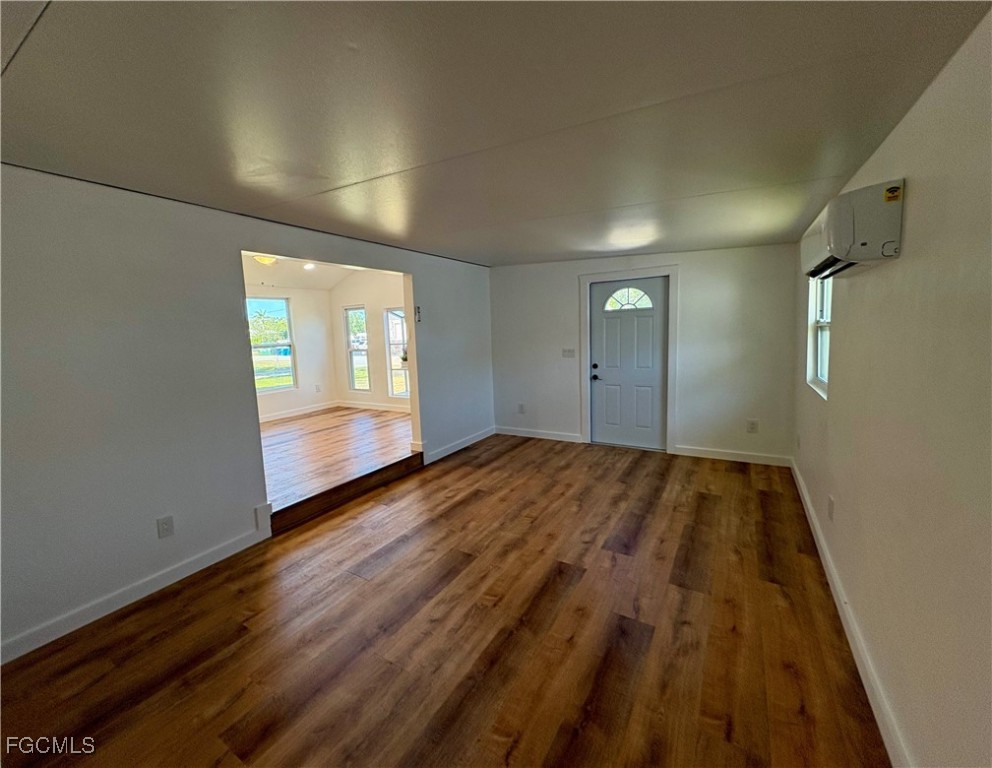 5675 Pine Island Road St. James City, FL 33956 - Photo 9 of 28 an empty room with wooden floor and windows