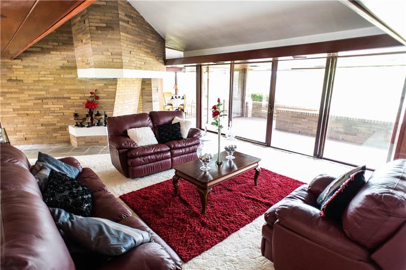 151 View Street Indiana, PA 15701 - Photo 2 of 15 Spacious Living Room with Decorative Fireplace, Vaulted Ceiling, Natural Sunlight, Sliding Doors leading out to Balcony, Tree-Line Views