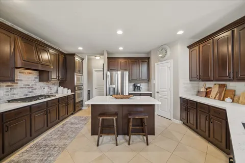 a kitchen with kitchen island granite countertop wooden cabinets and white appliances
