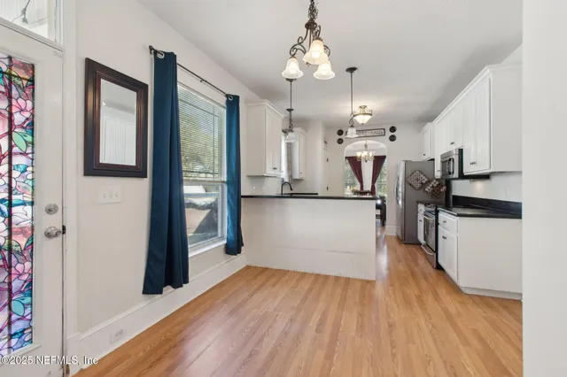 a kitchen with granite countertop a sink cabinets and wooden floor