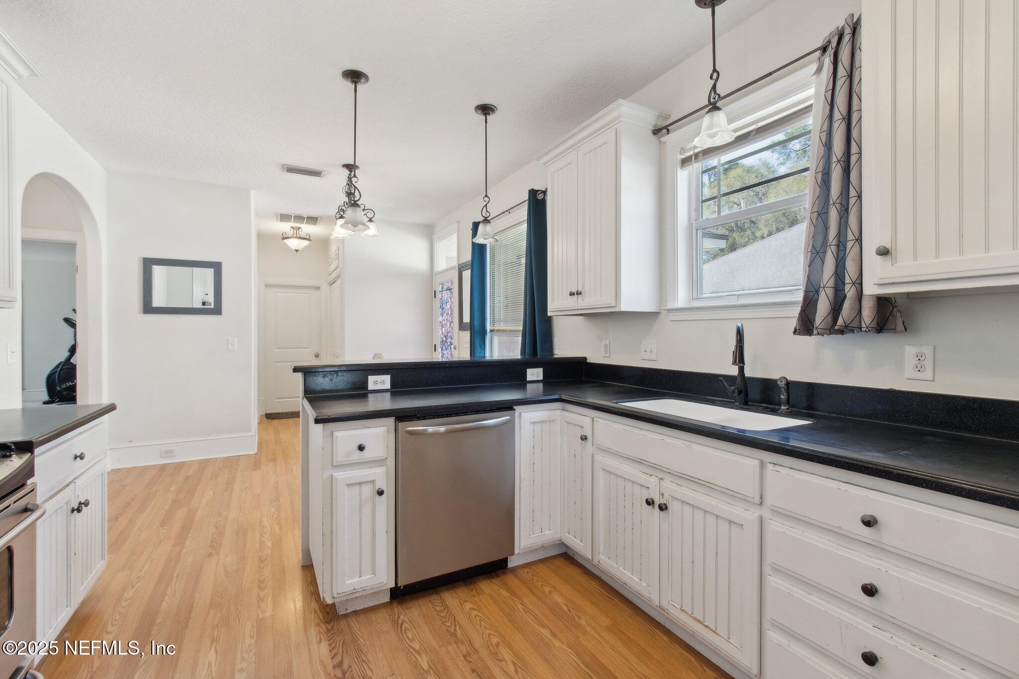 45107 Booth Street Callahan, FL 32011 - Photo 30 of 49 a kitchen with granite countertop a sink cabinets and wooden floor