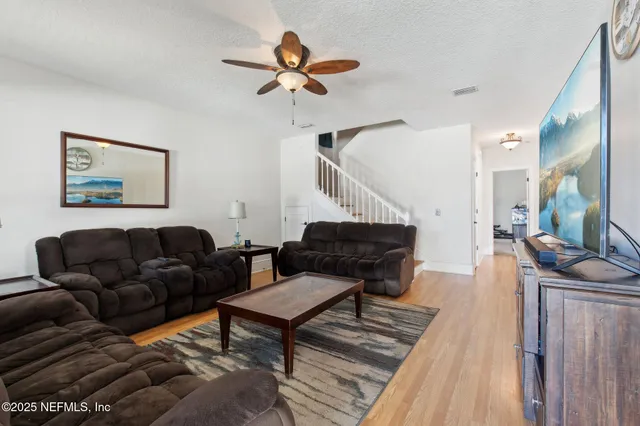 a living room with furniture and a wooden floor