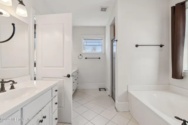 a bathroom with a tub sink and mirror