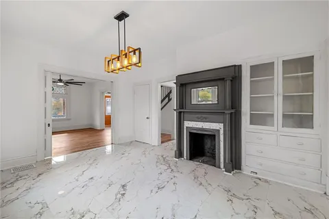 a view of an empty room with a fireplace and a window