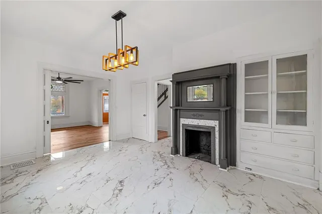 a view of an empty room with a fireplace and a window