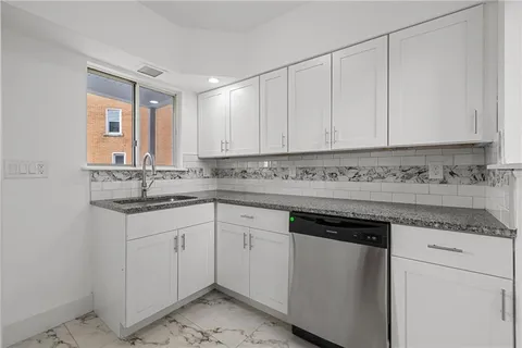 a kitchen with granite countertop white cabinets and white appliances