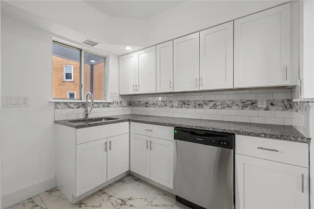 a kitchen with granite countertop white cabinets and white appliances