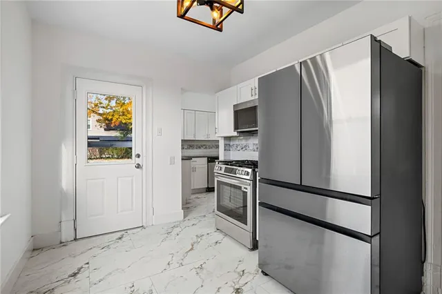 a kitchen with stainless steel appliances granite countertop a refrigerator and a stove top oven