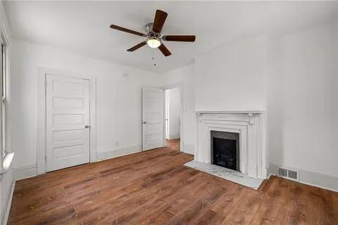 an empty room with ceiling fan and window