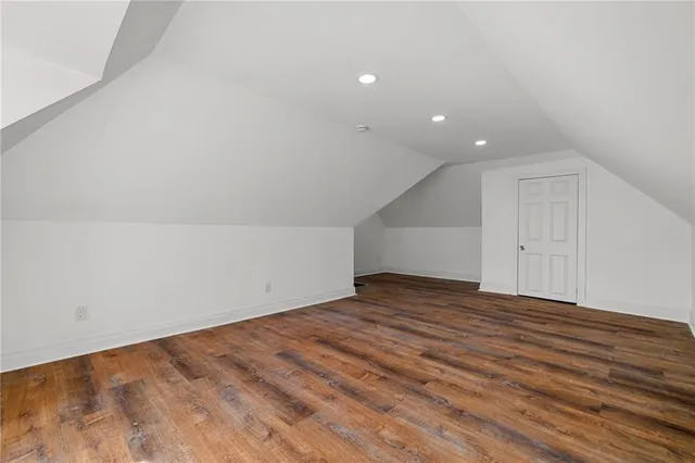a view of an empty room with wooden floor and closet