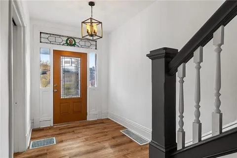 a view of hallway with stairs and wooden floor
