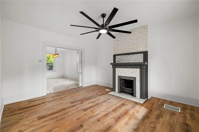 a view of empty room with wooden floor and ceiling fan