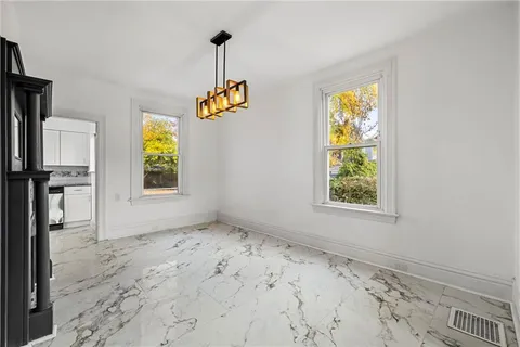 a view of empty room with windows and ceiling fan