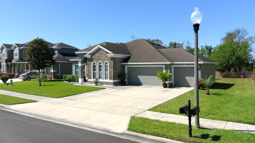 1991 Sanderlin Point Loop Apopka, FL 32703 - Photo 21 of 27 a front view of a house with a yard and green space
