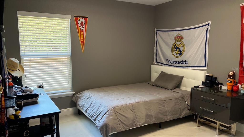 1991 Sanderlin Point Loop Apopka, FL 32703 - Photo 25 of 27 a bedroom with a bed and a desk