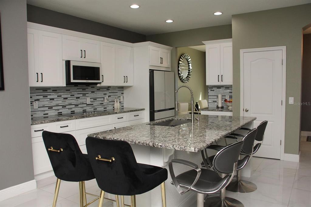 1991 Sanderlin Point Loop Apopka, FL 32703 - Photo 3 of 27 a kitchen with kitchen island granite countertop a sink and a refrigerator