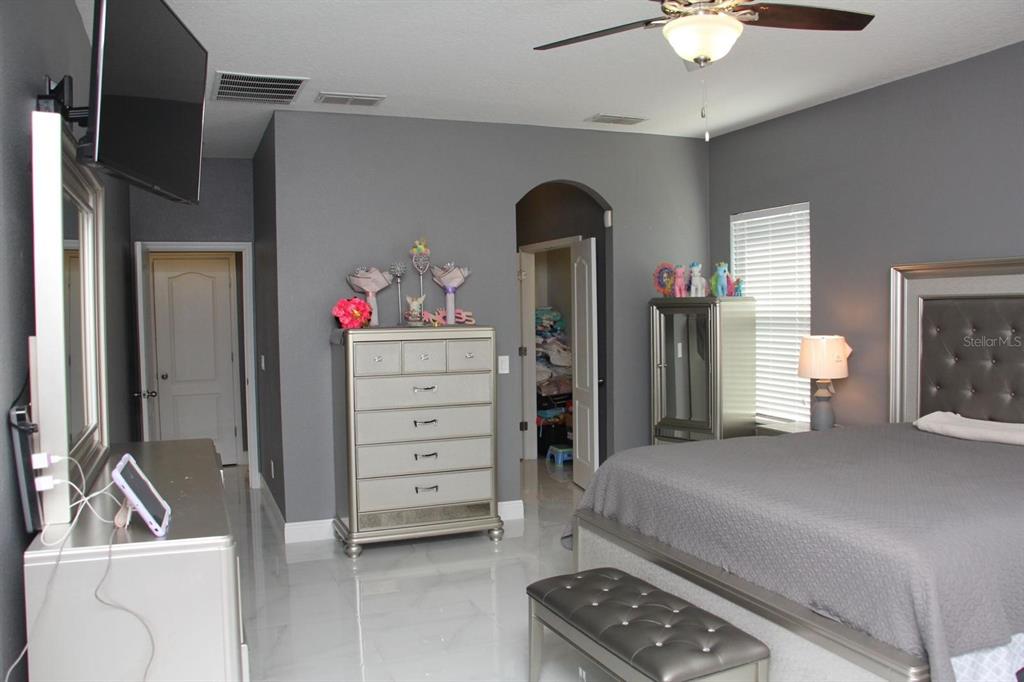 1991 Sanderlin Point Loop Apopka, FL 32703 - Photo 8 of 27 a bedroom with a bed and a chandelier