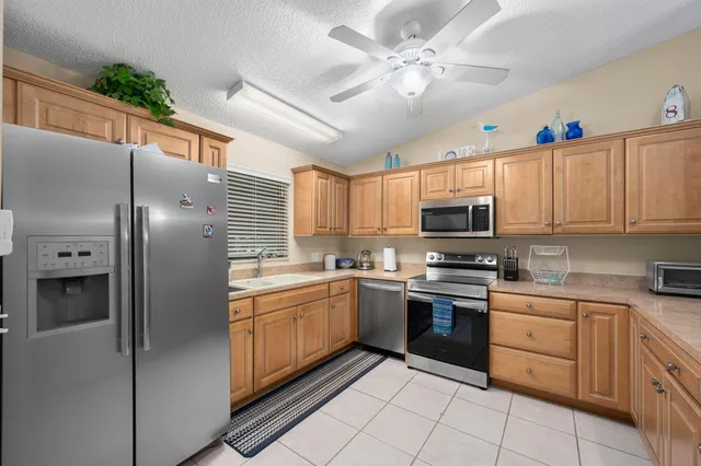 a kitchen with cabinets stainless steel appliances and a window