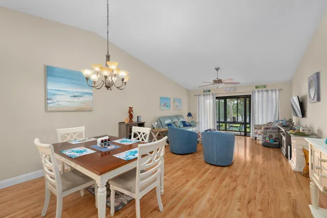 a view of a dining room with furniture a chandelier and wooden floor