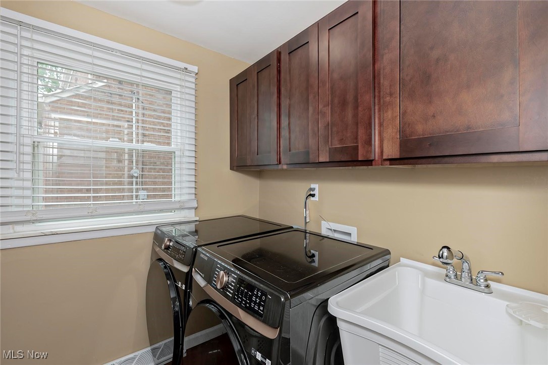 2381 Charney Road Cleveland, OH 44118 - Photo 17 of 47 Laundry area with washer and clothes dryer and cabinet space