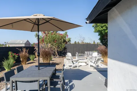 a view of deck with furniture and umbrella
