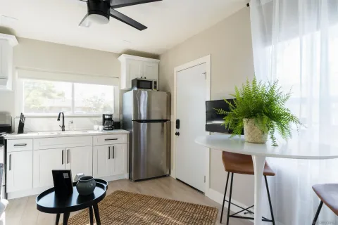 a kitchen with appliances cabinets and chair