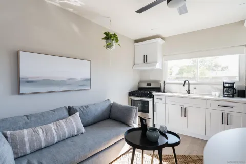 a kitchen with stainless steel appliances a sink a window and white cabinets