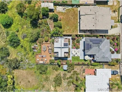 an aerial view of residential houses with outdoor space and parking