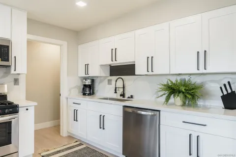 a kitchen with stainless steel appliances granite countertop a sink a stove and a refrigerator