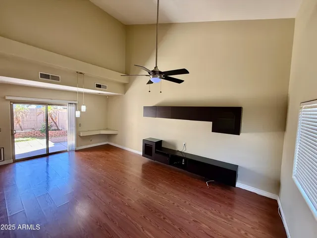 a view of a livingroom with wooden floor and a ceiling fan
