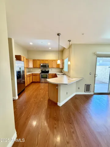 a view of a room with wooden floor ceiling fan and window