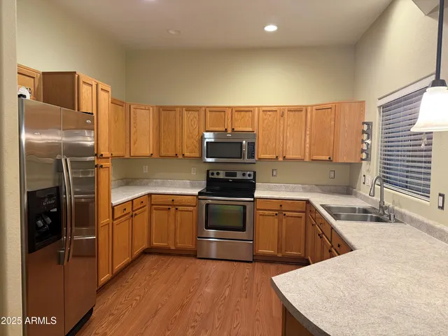 a kitchen with stainless steel appliances granite countertop a stove a sink and a refrigerator