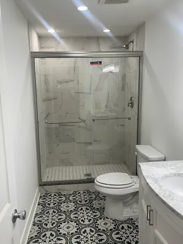 a bathroom with a shower toilet and sink