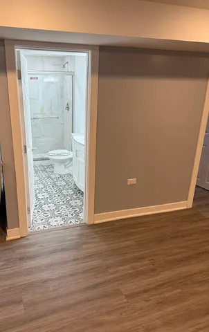 an empty room with wooden floor and mirror