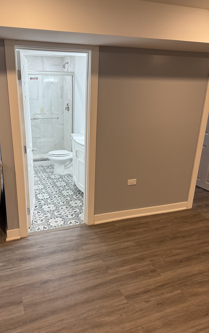 13621 Homan Avenue Robbins, IL 60472 - Photo 16 of 25 an empty room with wooden floor and mirror