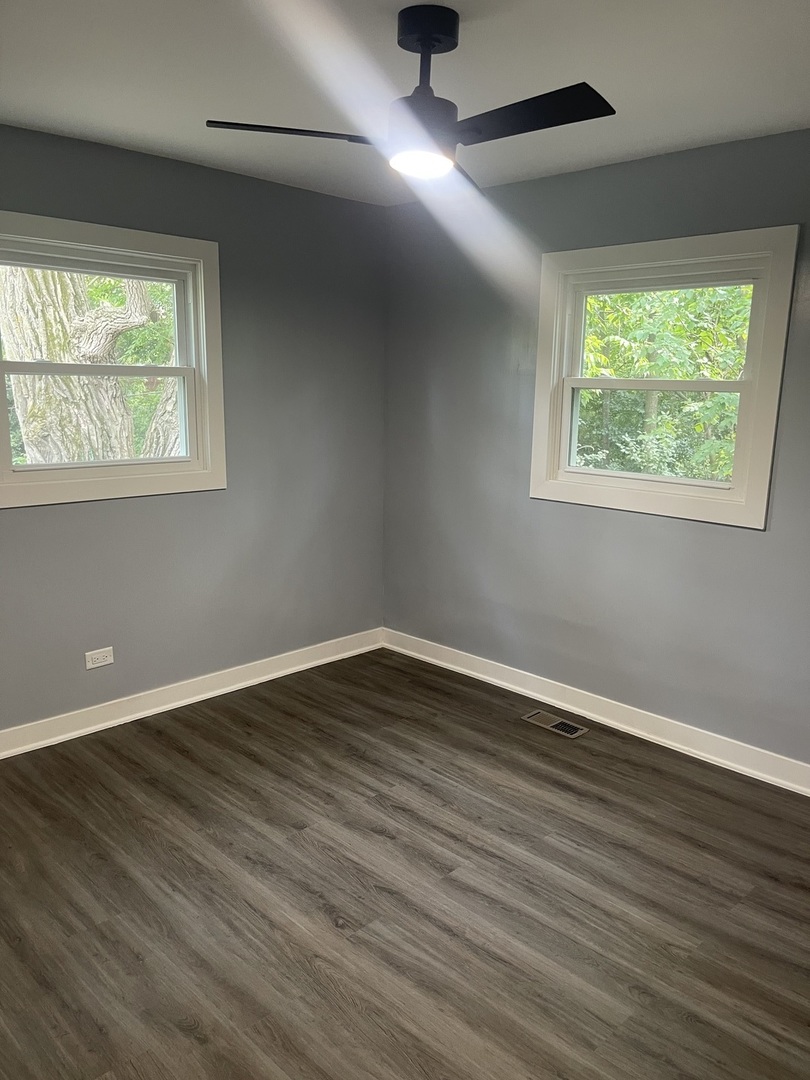 13621 Homan Avenue Robbins, IL 60472 - Photo 8 of 25 a view of an empty room with wooden floor and a window